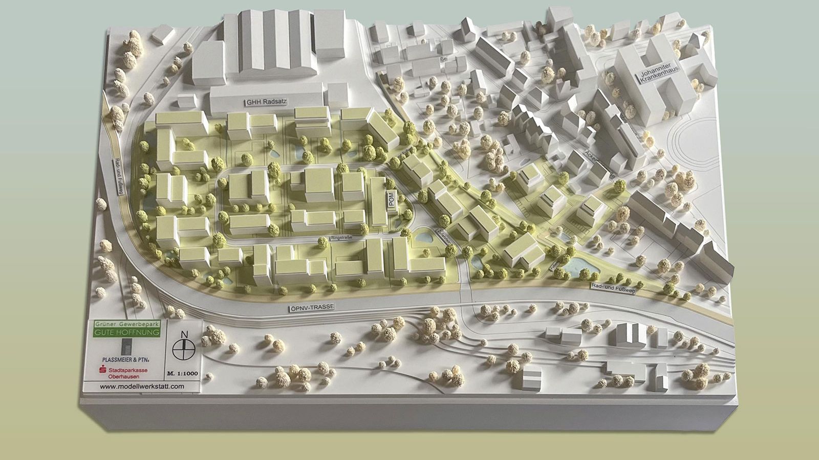 Architektonisches Modell eines geplanten Gewerbegebiets mit farblich hervorgehobenen Neubauten.